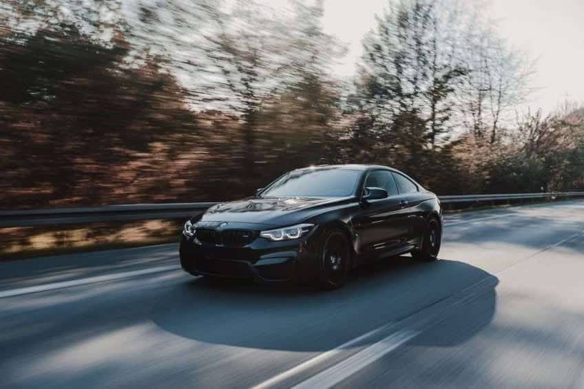 black car driving on road