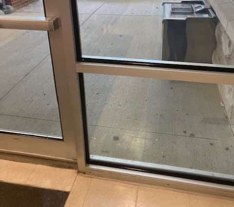 Impact protection attachment system applied to the entrance of a building by Professional Window Tinting.