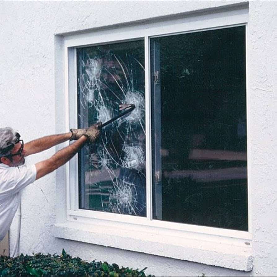 A demonstration performed by the gentleman in this picture shows that window film can withstand a myriad of blows from a crowbar or other blunt instrument.